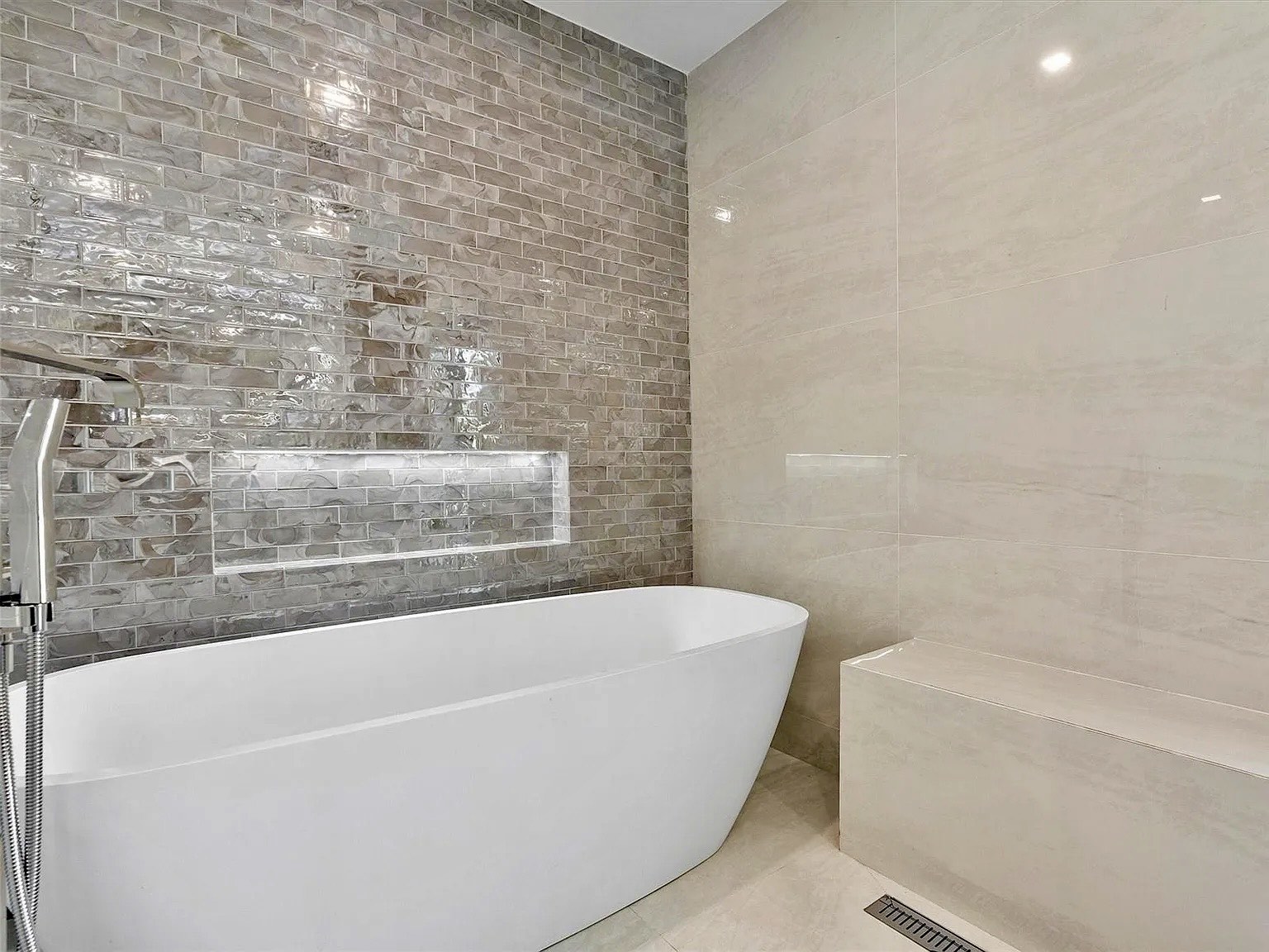 Baño principal de Frow Avenue Residence con bañera exenta, revestimiento texturizado y ducha integrada
