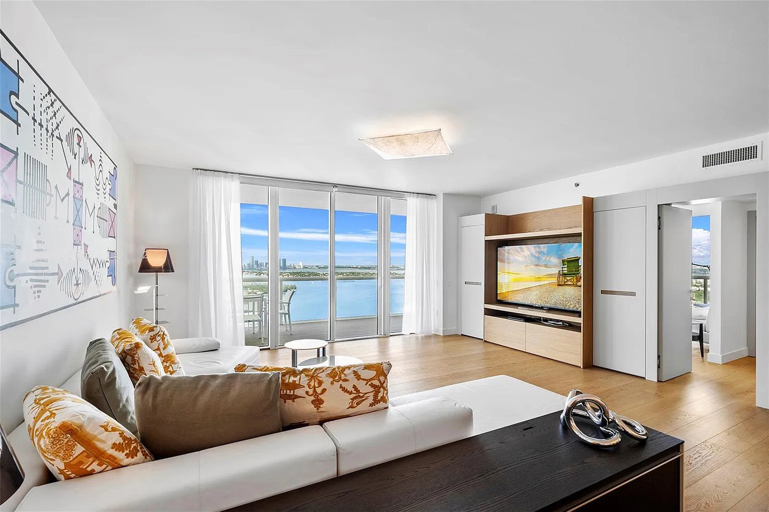 Sala de Icon South Beach Apartment con pared audiovisual integrada y vistas abiertas al agua