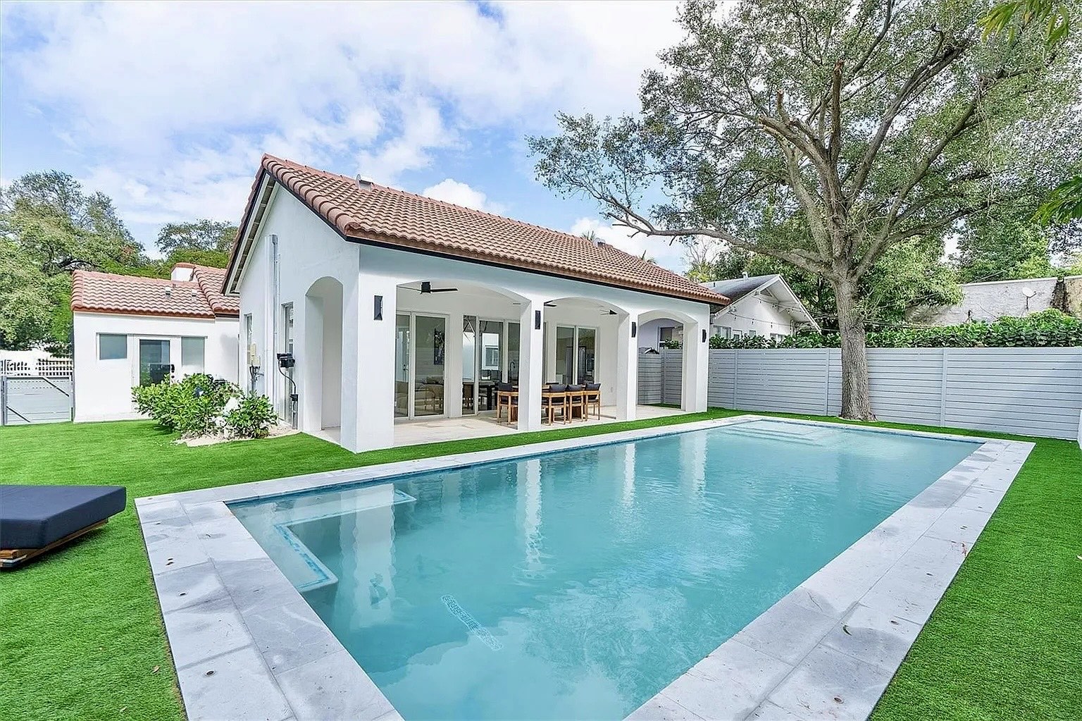 Transformación de NE 45th Street Residence con piscina y terraza sombreada en Miami