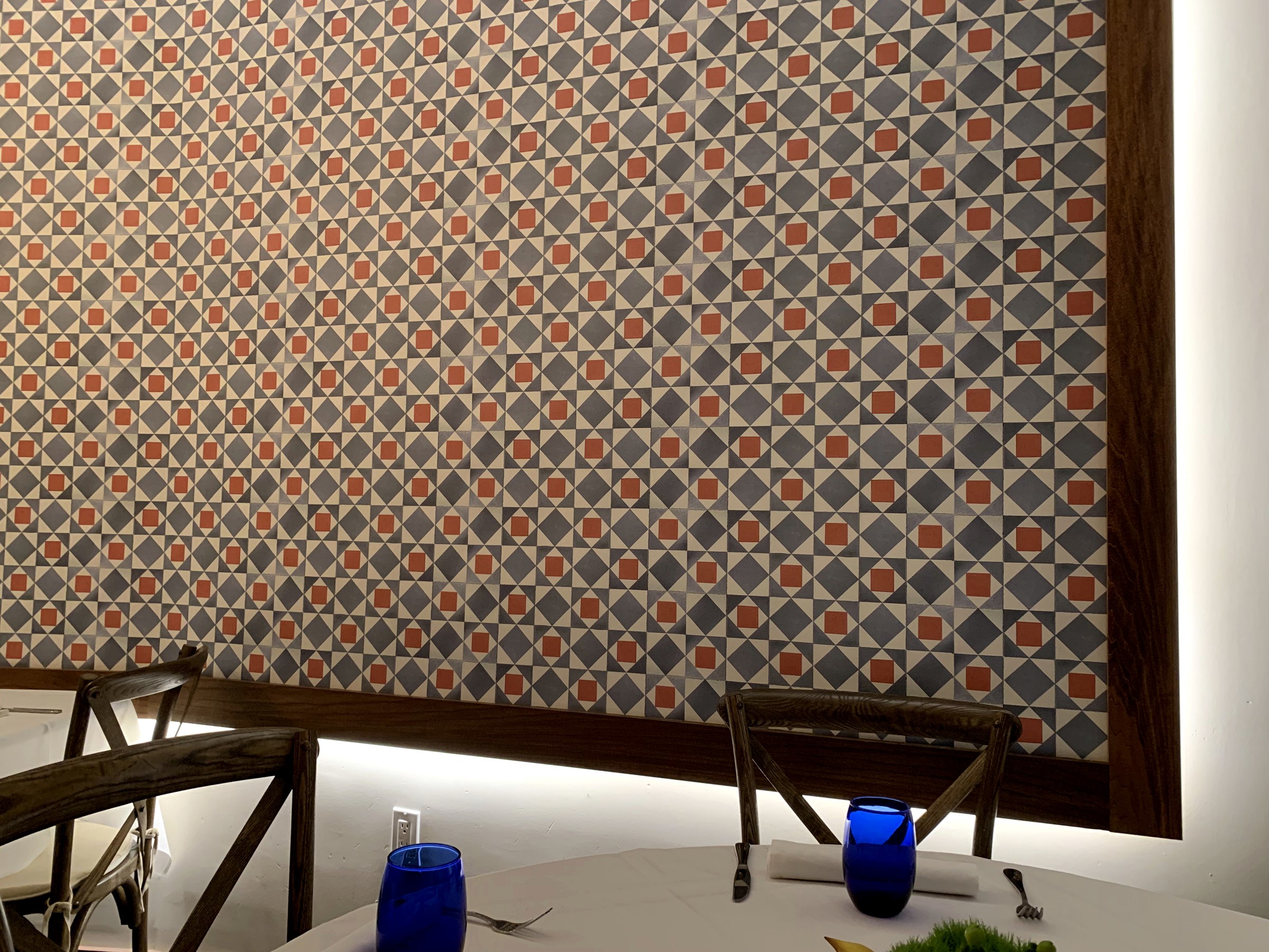 Geometría inspirada en la cerámica española enmarcada en madera oscura en Pairings Restaurant