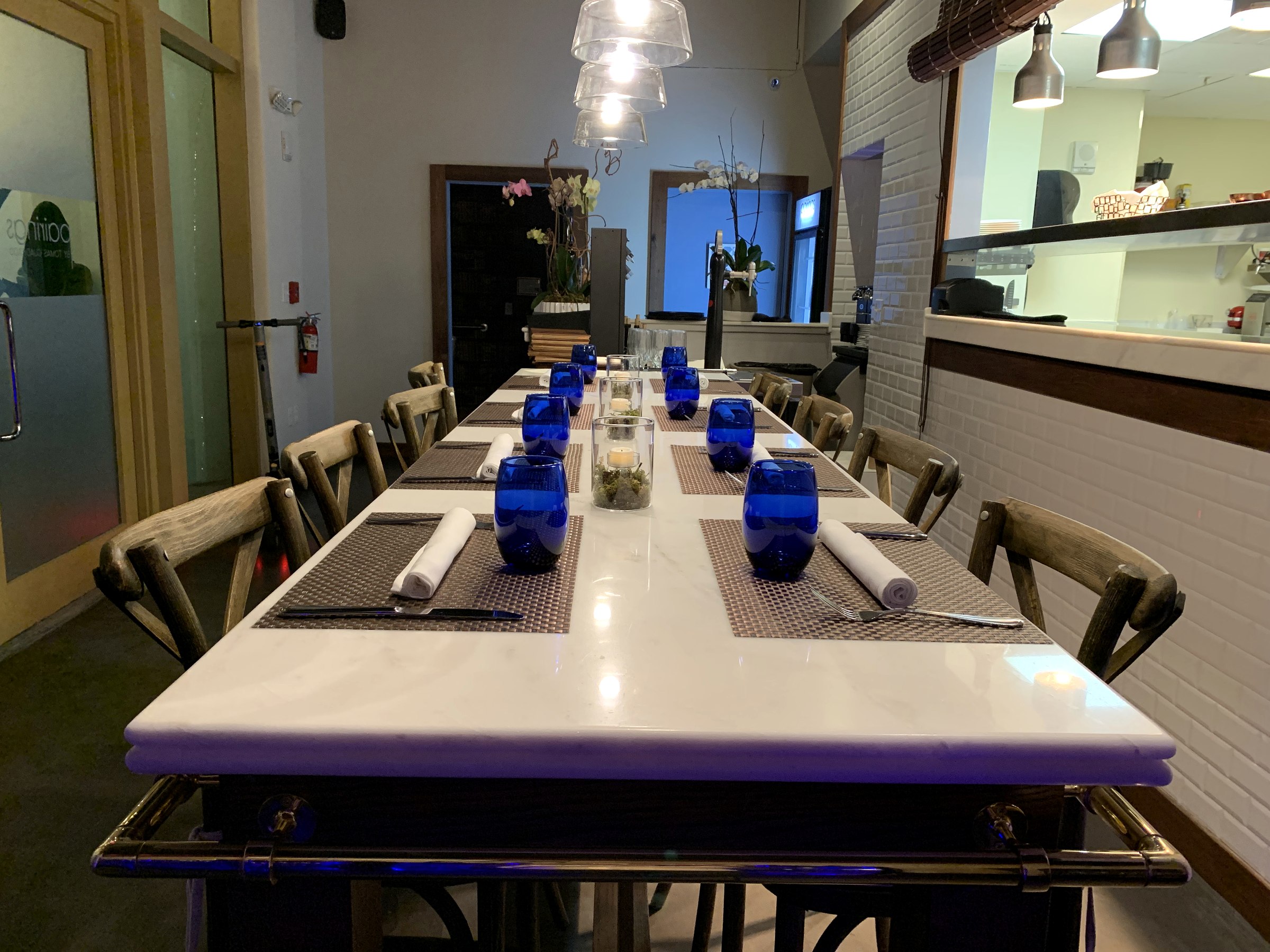 Gran mesa comunitaria de Pairings Restaurant frente a la cocina abierta en Miami