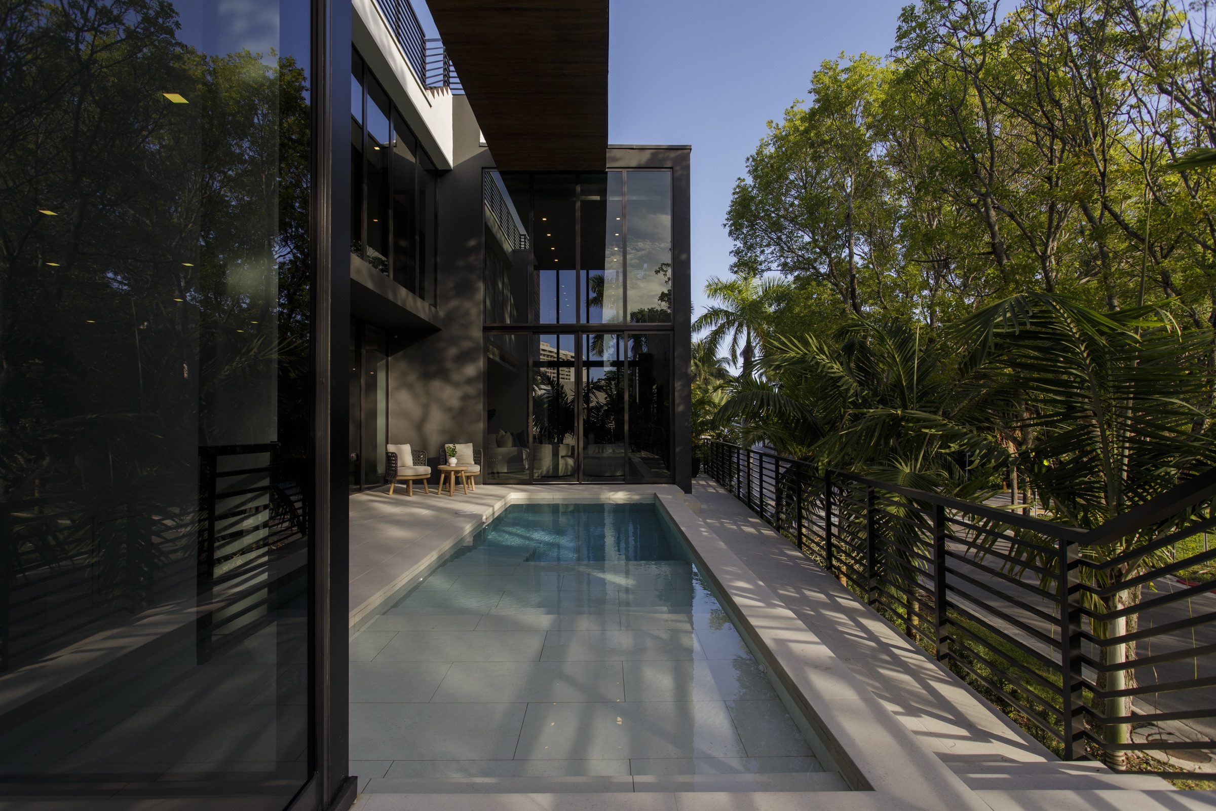 Aerial view of Fair Isle Residence showing the raised courtyard, pool, roof and mature Coconut Grove canopy.