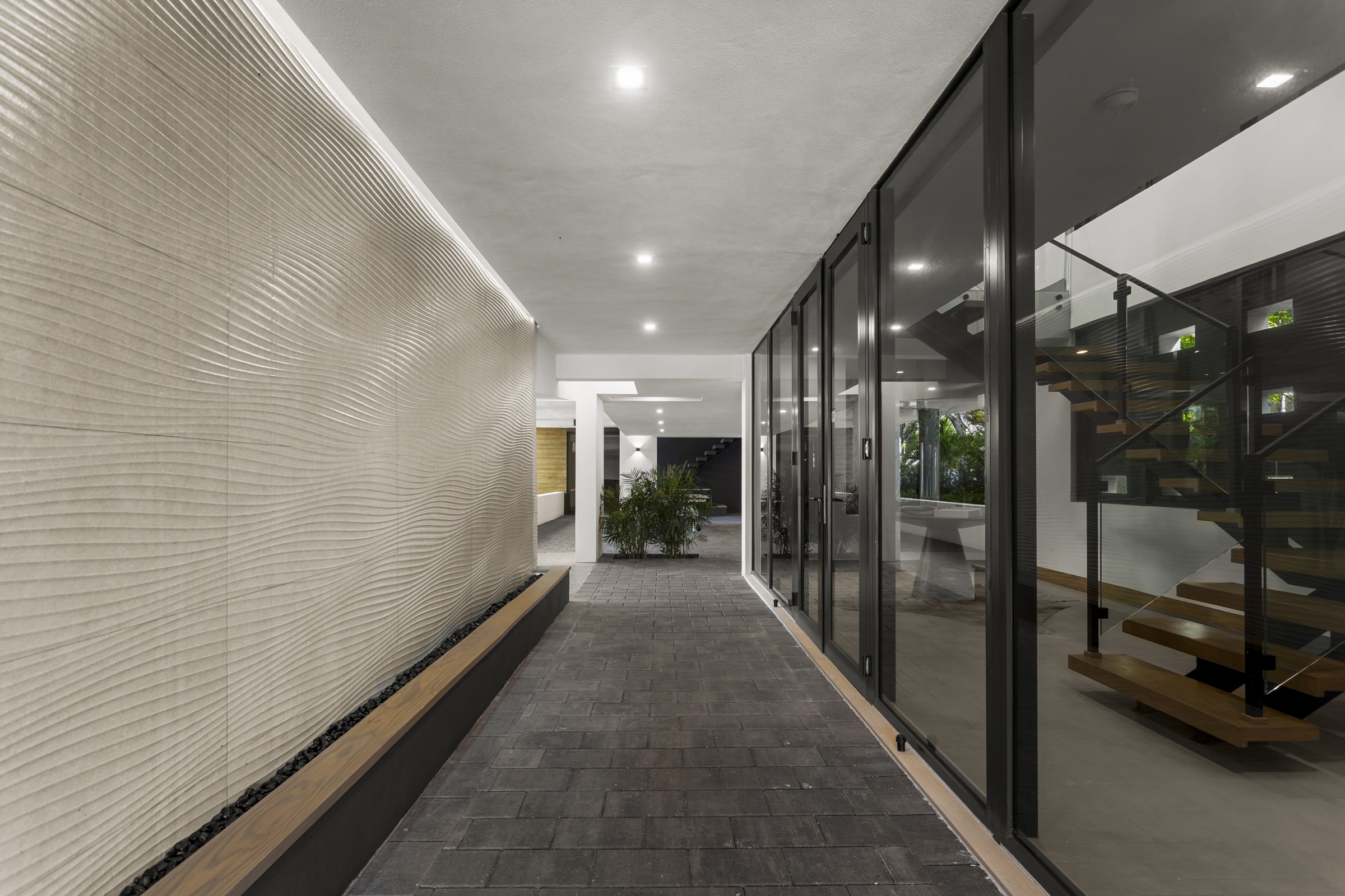 Shaded lower porch beneath the raised Fair Isle Residence courtyard in Coconut Grove.
