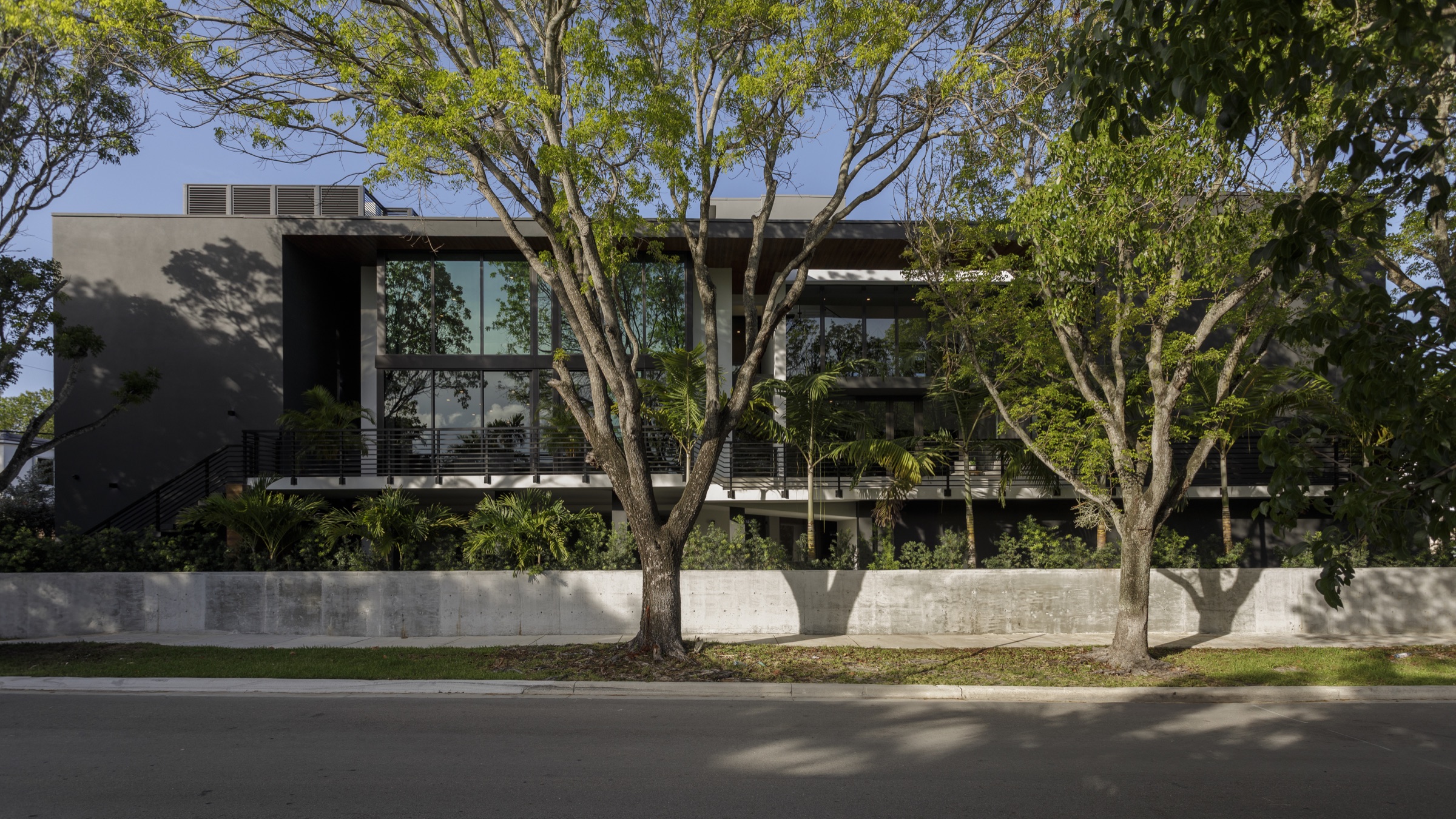 Fair Isle Residence from the street showing the raised garden, lower porch and planted privacy filter.