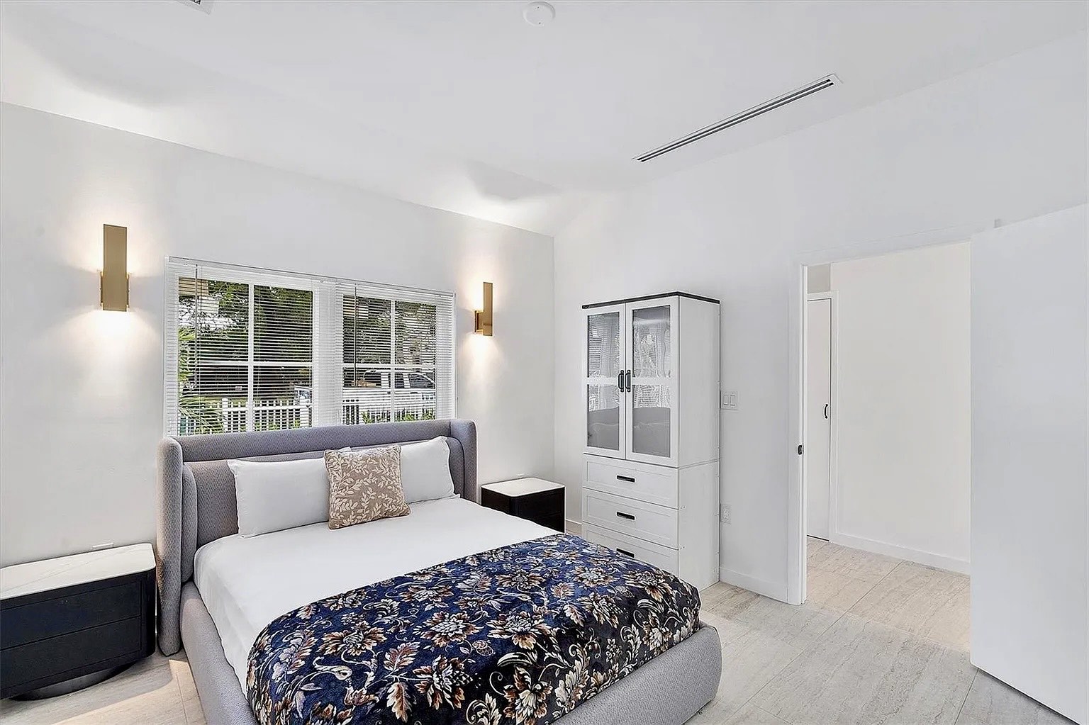 Bright bedroom at NE 45th Street Residence with garden views and warm wall lighting