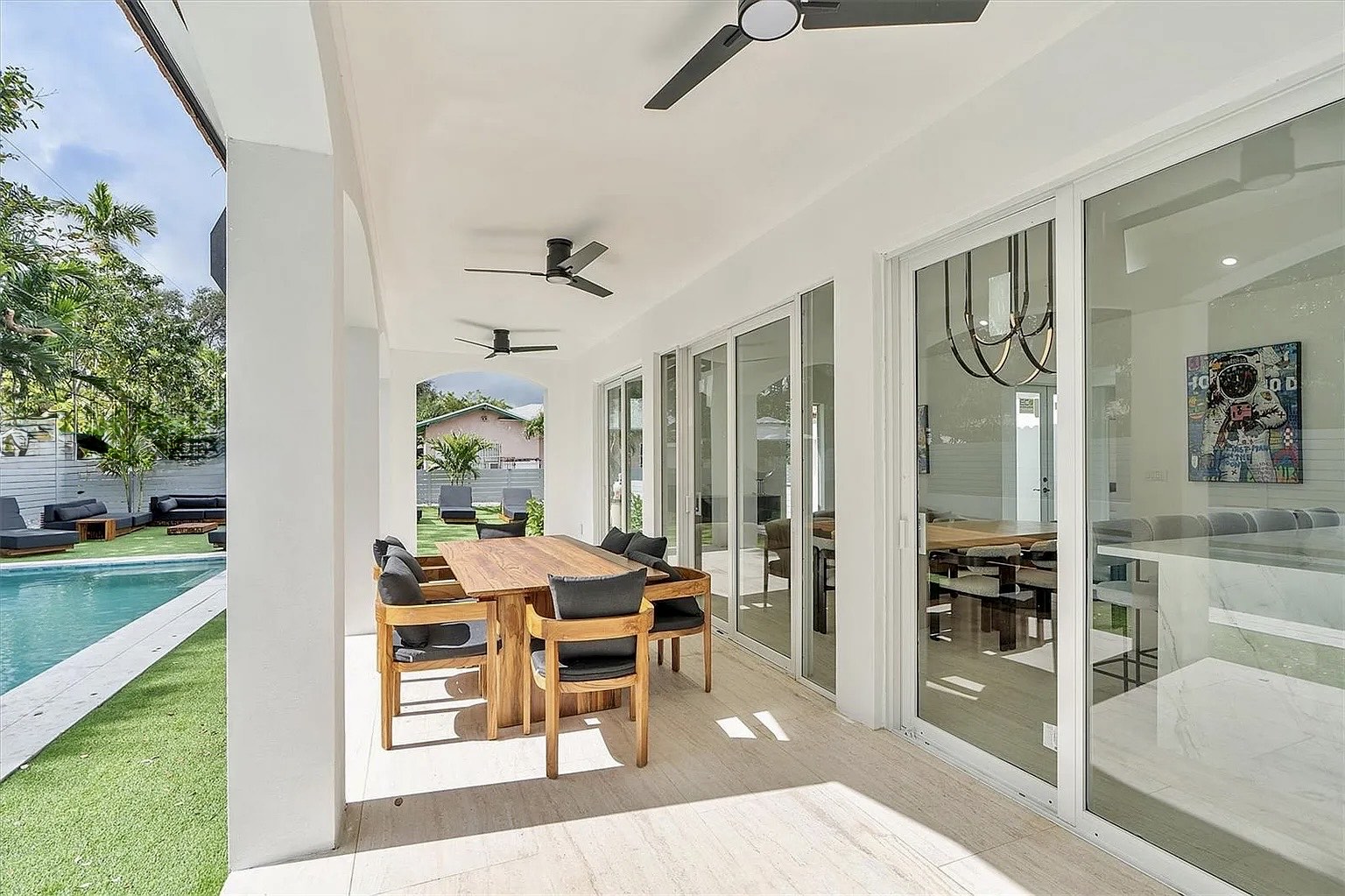 Deep covered terrace at NE 45th Street Residence connecting interior living spaces with the pool and garden in Miami.