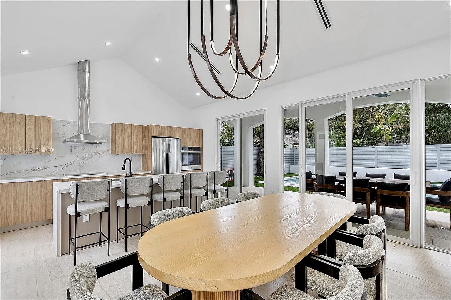 Open living and dining space at NE 45th Street Residence facing the covered terrace and pool